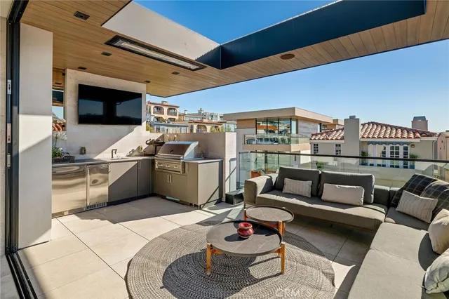a living room with furniture a flat screen tv and kitchen view