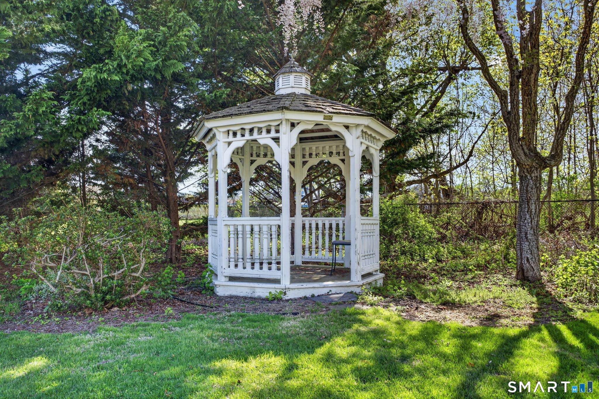 61 Ingham Hill Road Old Saybrook, CT 06475 - Photo 27 of 32 a view of a wooden house with a small yard and large tree
