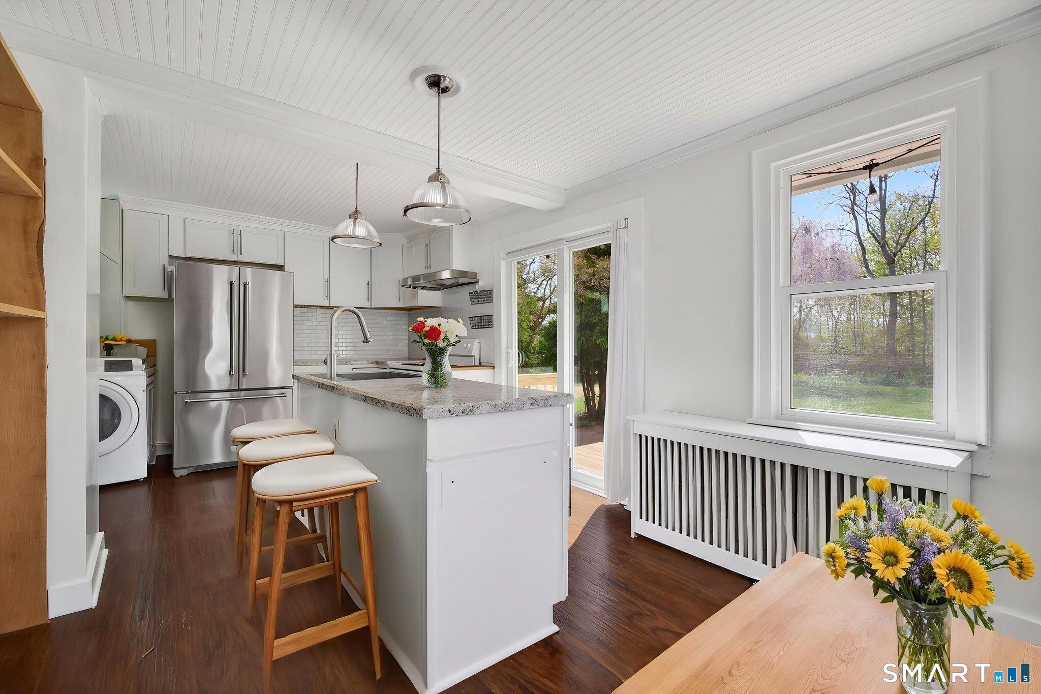 61 Ingham Hill Road Old Saybrook, CT 06475 - Photo 6 of 32 a kitchen with stainless steel appliances a refrigerator a sink dishwasher a stove and white cabinets with wooden floor