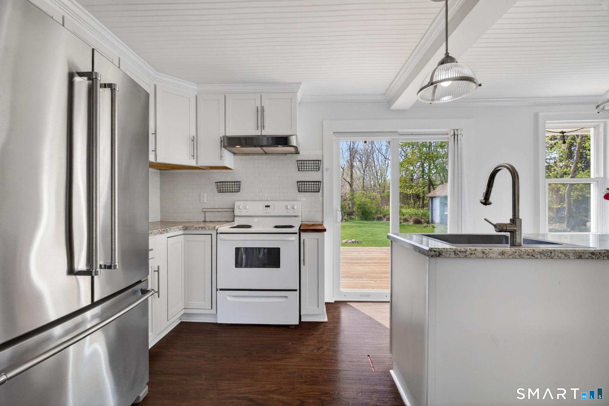 61 Ingham Hill Road Old Saybrook, CT 06475 - Photo 7 of 32 a kitchen with a stove a sink and a refrigerator