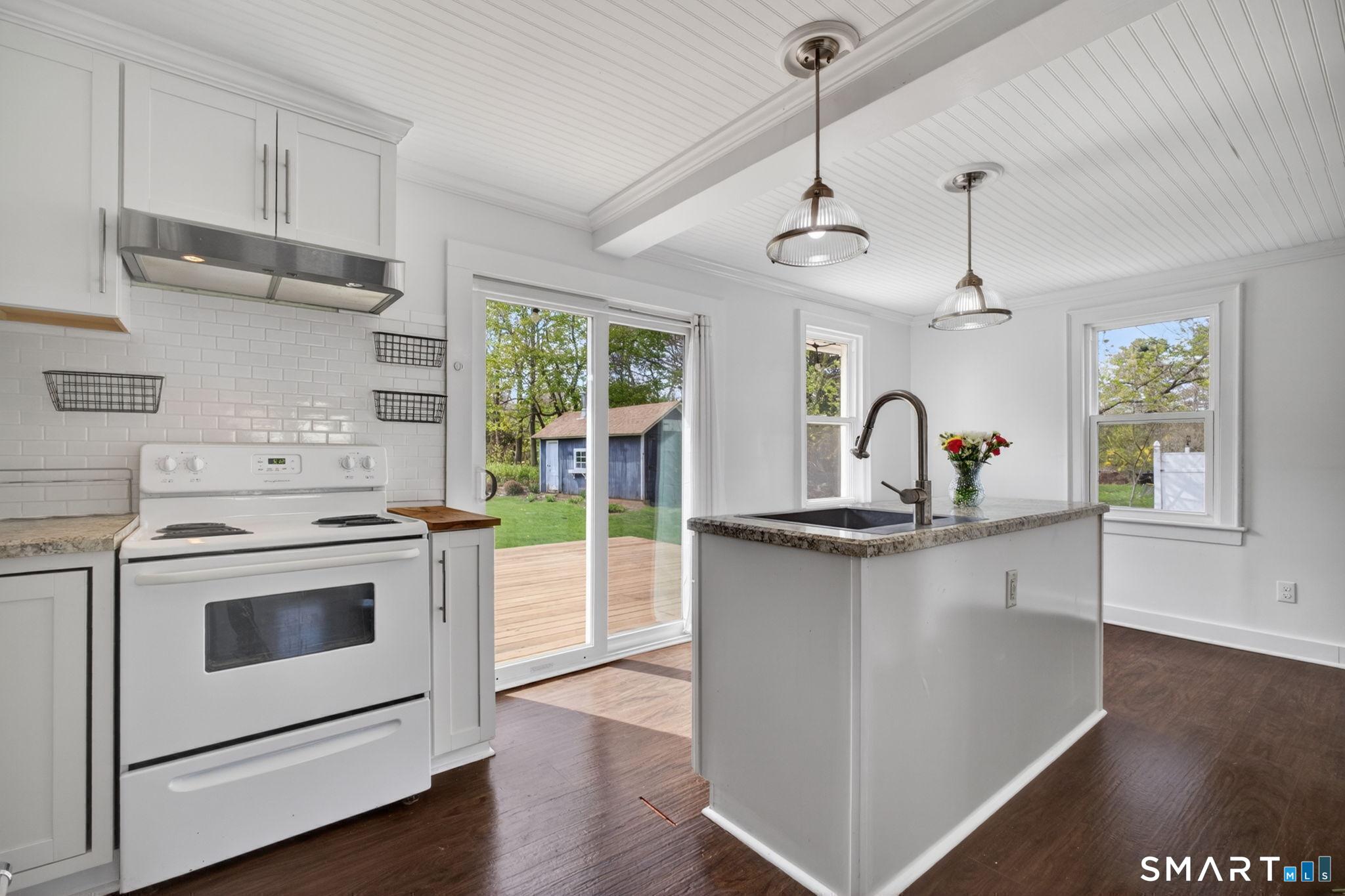 61 Ingham Hill Road Old Saybrook, CT 06475 - Photo 9 of 32 a kitchen with stainless steel appliances a stove a sink and a chandelier