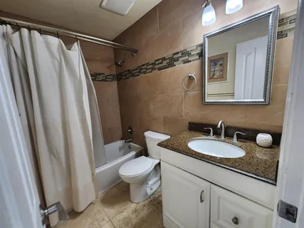 a bathroom with a granite countertop sink toilet and shower