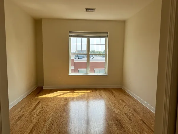 a view of an empty room with wooden floor