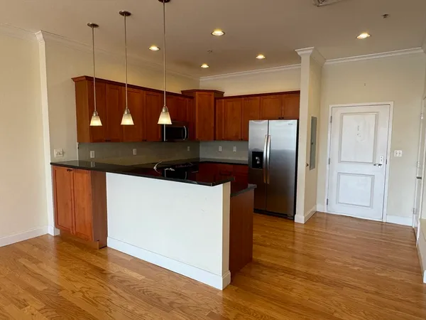 a kitchen with stainless steel appliances granite countertop a refrigerator a sink and a stove