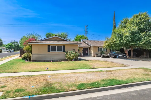 a front view of a house with a garden and yard