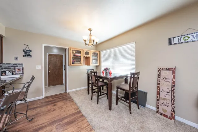a view of a dining room with furniture and chandelier