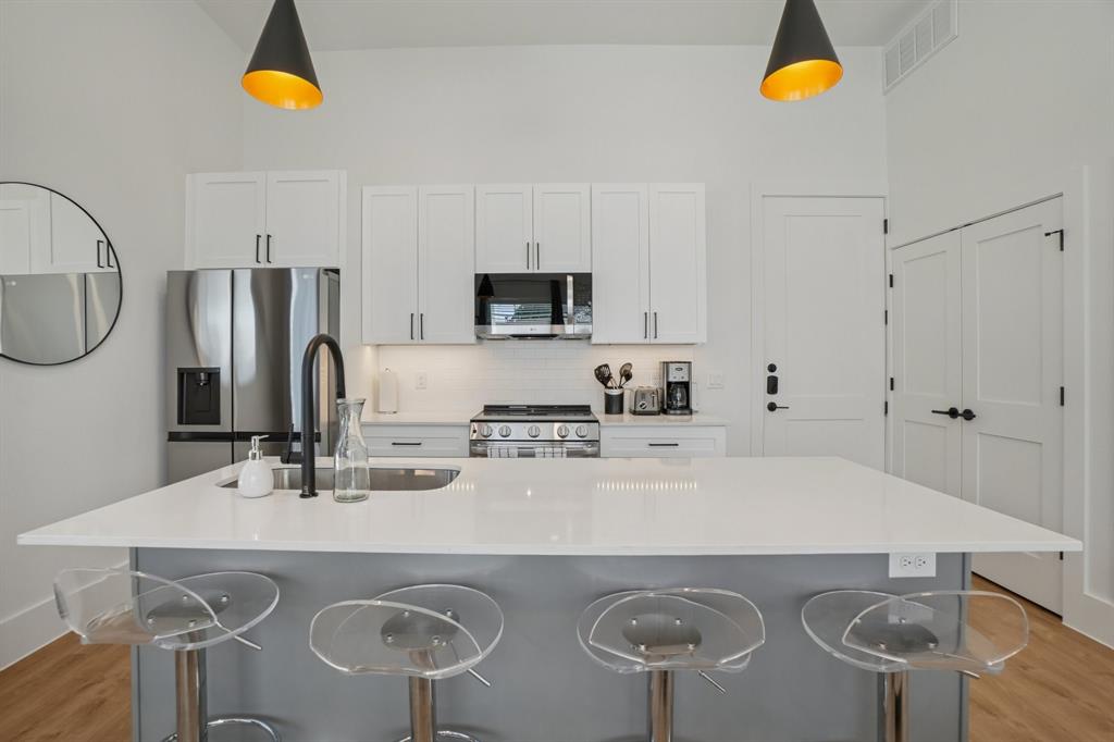 6418 Maple Avenue, Unit 307 Dallas, TX 75235 - Photo 3 of 16 a kitchen with stainless steel appliances granite countertop a sink a stove a refrigerator cabinets and chairs