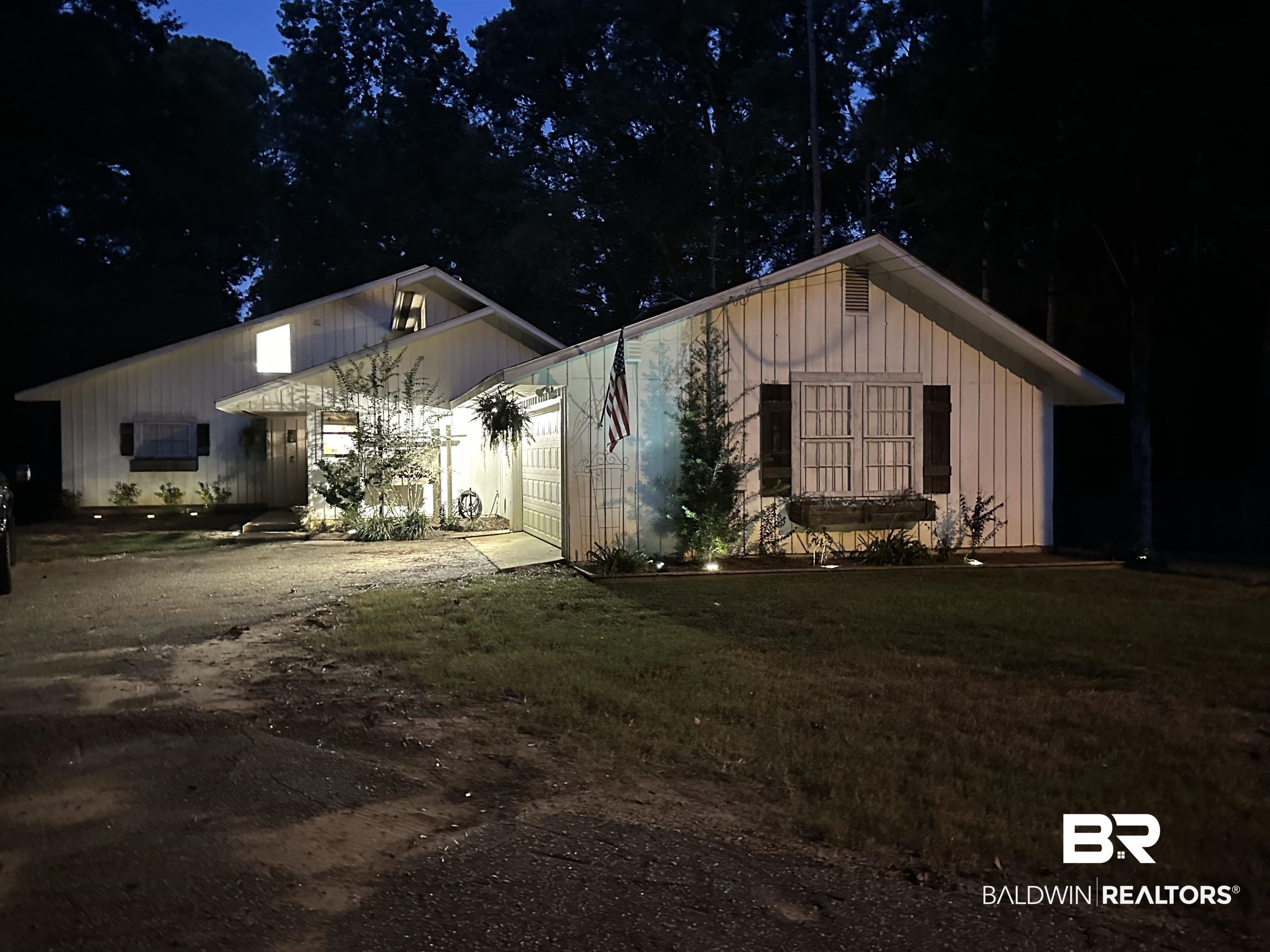 494 Ridgewood Drive Daphne, AL 36526 - Photo 39 of 40 Property exterior at night with a lawn and a garage