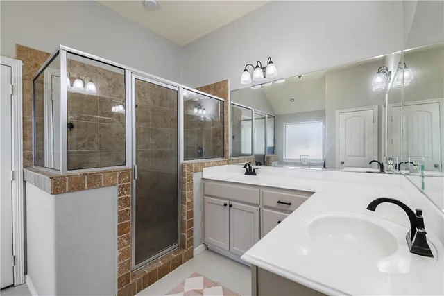 a bathroom with a sink and mirror with bathtub