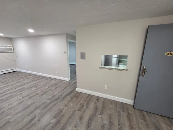 a view of an empty room with wooden floor