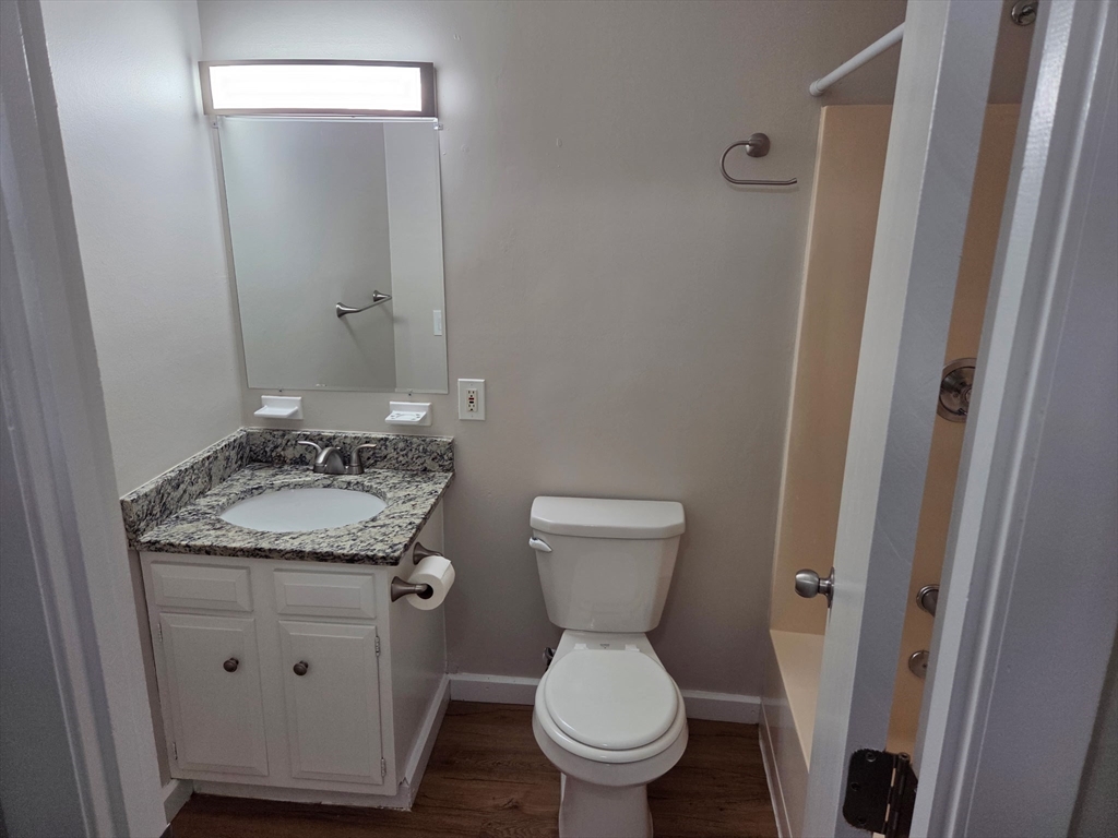 25 Ekman Street, Unit 3H Worcester, MA 01607 - Photo 5 of 7 a bathroom with a granite countertop toilet and a sink