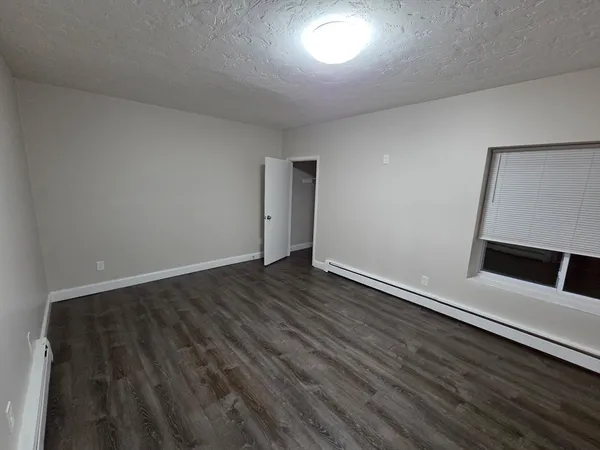 an empty room with wooden floor and window