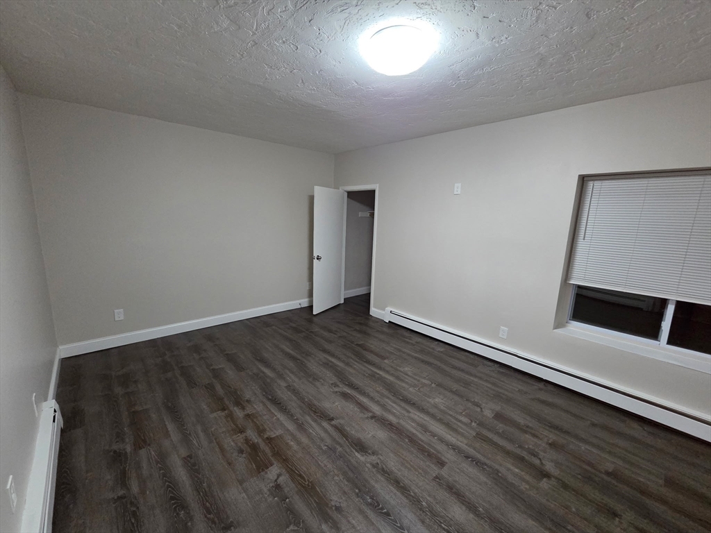 25 Ekman Street, Unit 3H Worcester, MA 01607 - Photo 6 of 7 an empty room with wooden floor and window