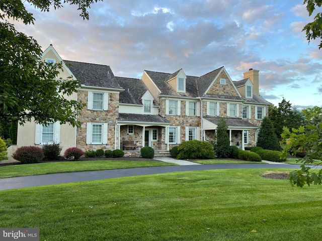 a front view of a house with garden and trees