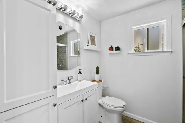 a bathroom with a sink vanity mirror and toilet