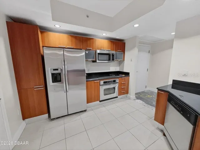 a kitchen with granite countertop a refrigerator and a sink