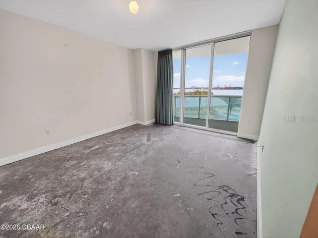 an empty room with floor to ceiling windows and an outdoor view