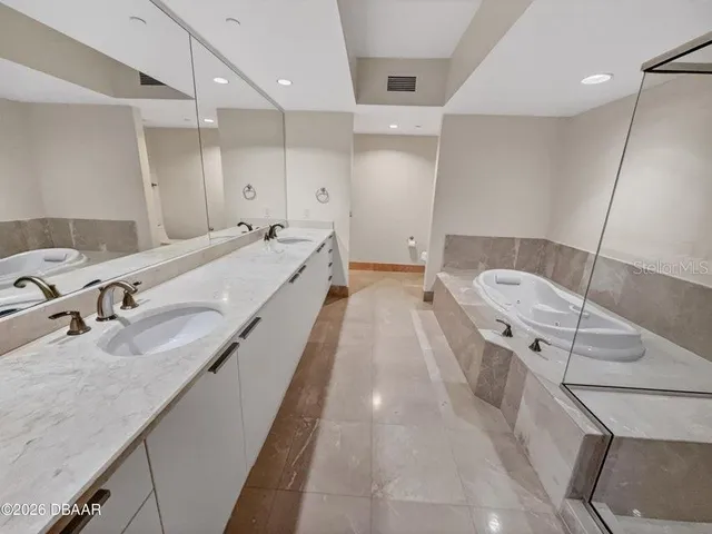 a bathroom with a tub sink and mirror