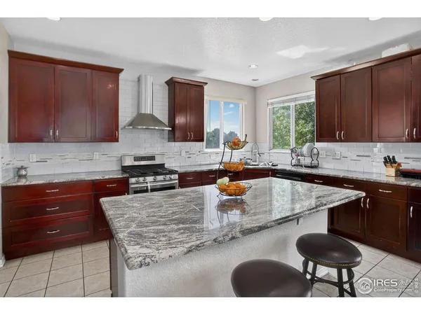 a kitchen with a sink a stove a refrigerator cabinets and a window
