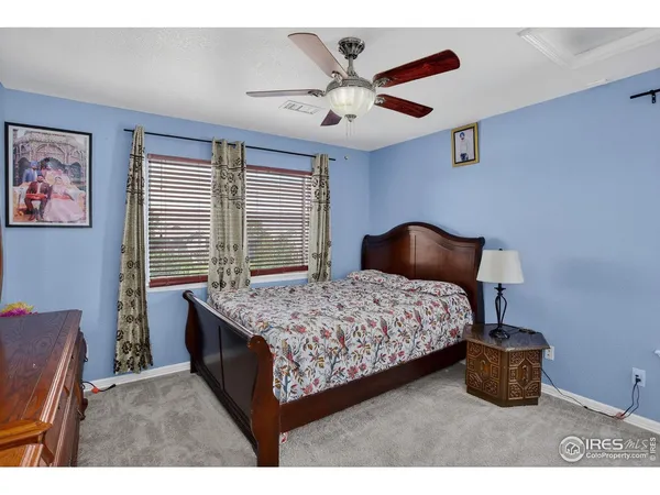 a bedroom with a bed and a painting on the wall