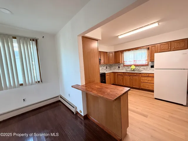 a kitchen with wooden floors and white appliances