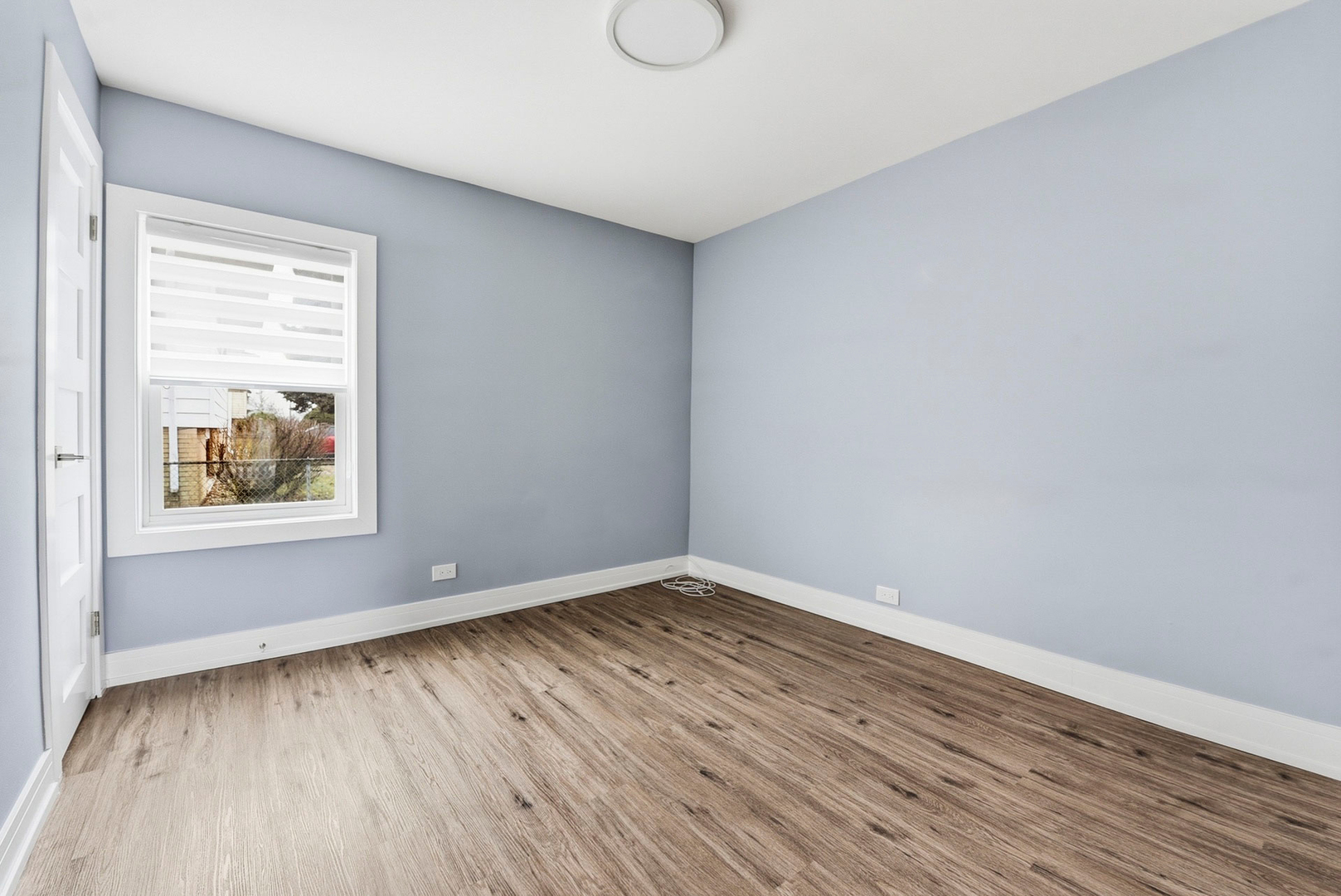 7303 West 75th Street Bridgeview, IL 60455 - Photo 18 of 48 a view of an empty room with wooden floor and a window