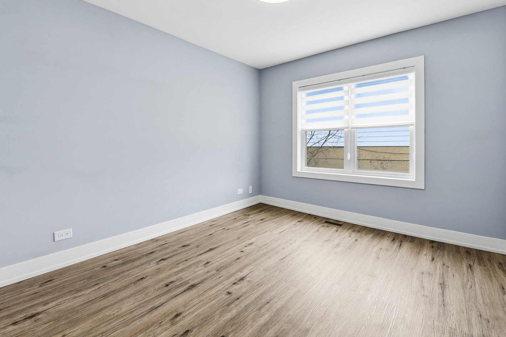 7303 West 75th Street Bridgeview, IL 60455 - Photo 19 of 48 a view of an empty room with wooden floor and a window