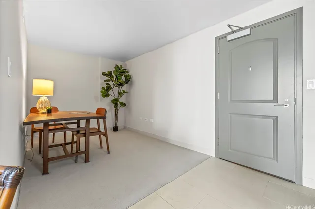 a dining room with furniture and a potted plant