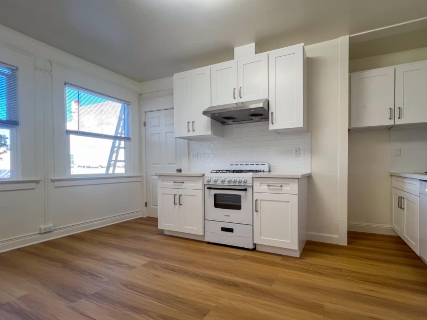 1206 Burlingame Avenue, Unit 2 Burlingame, CA 94010 - Photo 2 of 6 a kitchen with stainless steel appliances white cabinets and a wooden floor