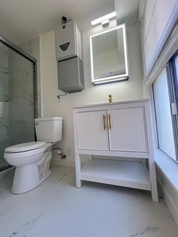 a bathroom with a toilet sink and mirror