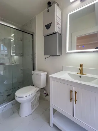 a bathroom with a toilet sink a mirror and shower