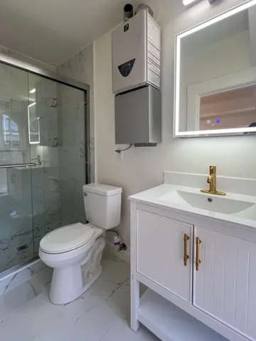 a bathroom with a toilet sink a mirror and shower