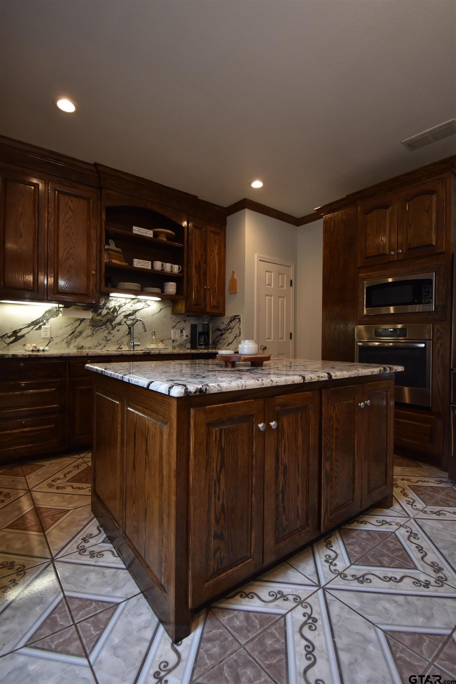 7727 Knowles Trace Tyler, TX 75708 - Photo 15 of 34 a kitchen with kitchen island granite countertop a sink and cabinets
