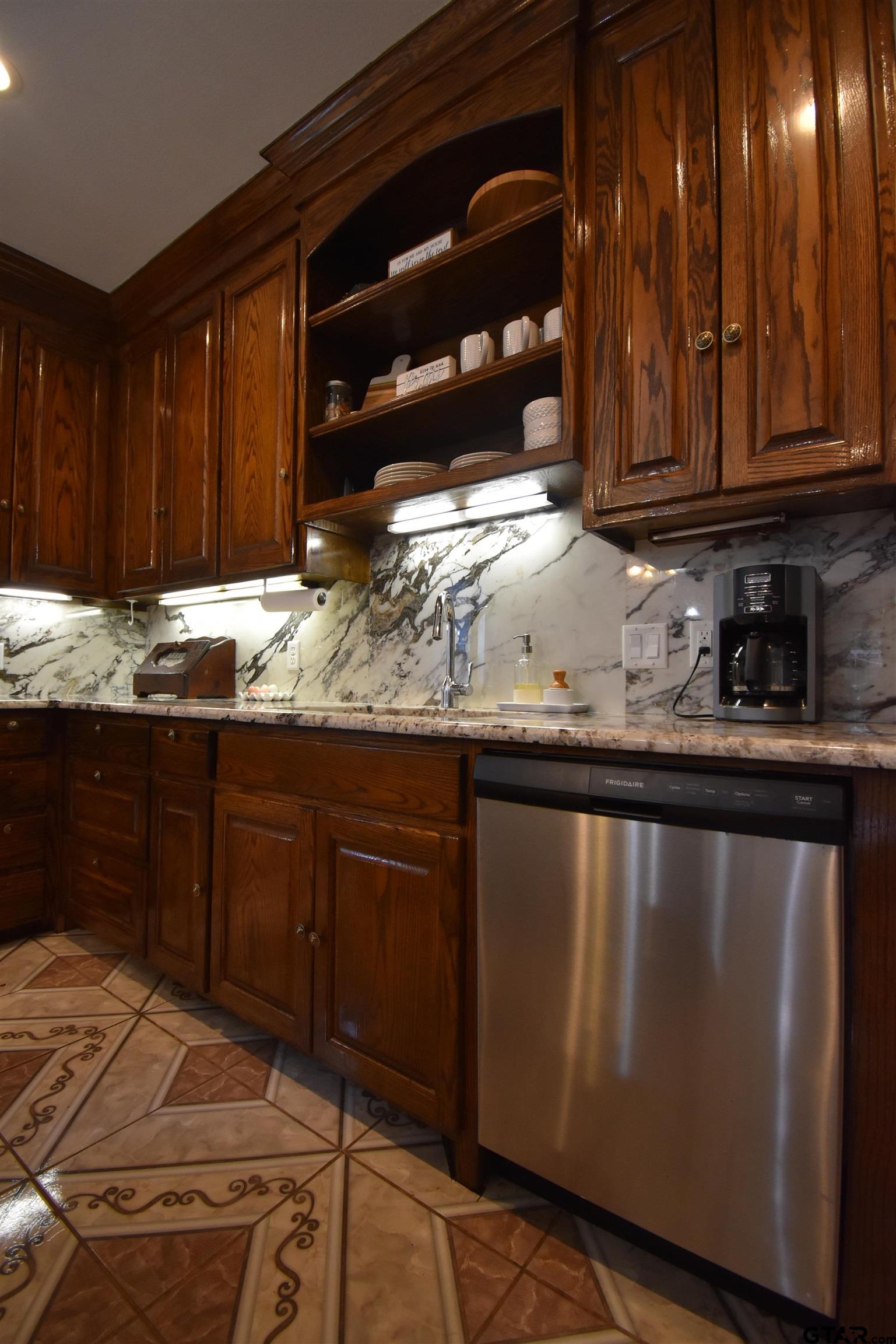 7727 Knowles Trace Tyler, TX 75708 - Photo 16 of 34 a kitchen with granite countertop wooden cabinets and a sink