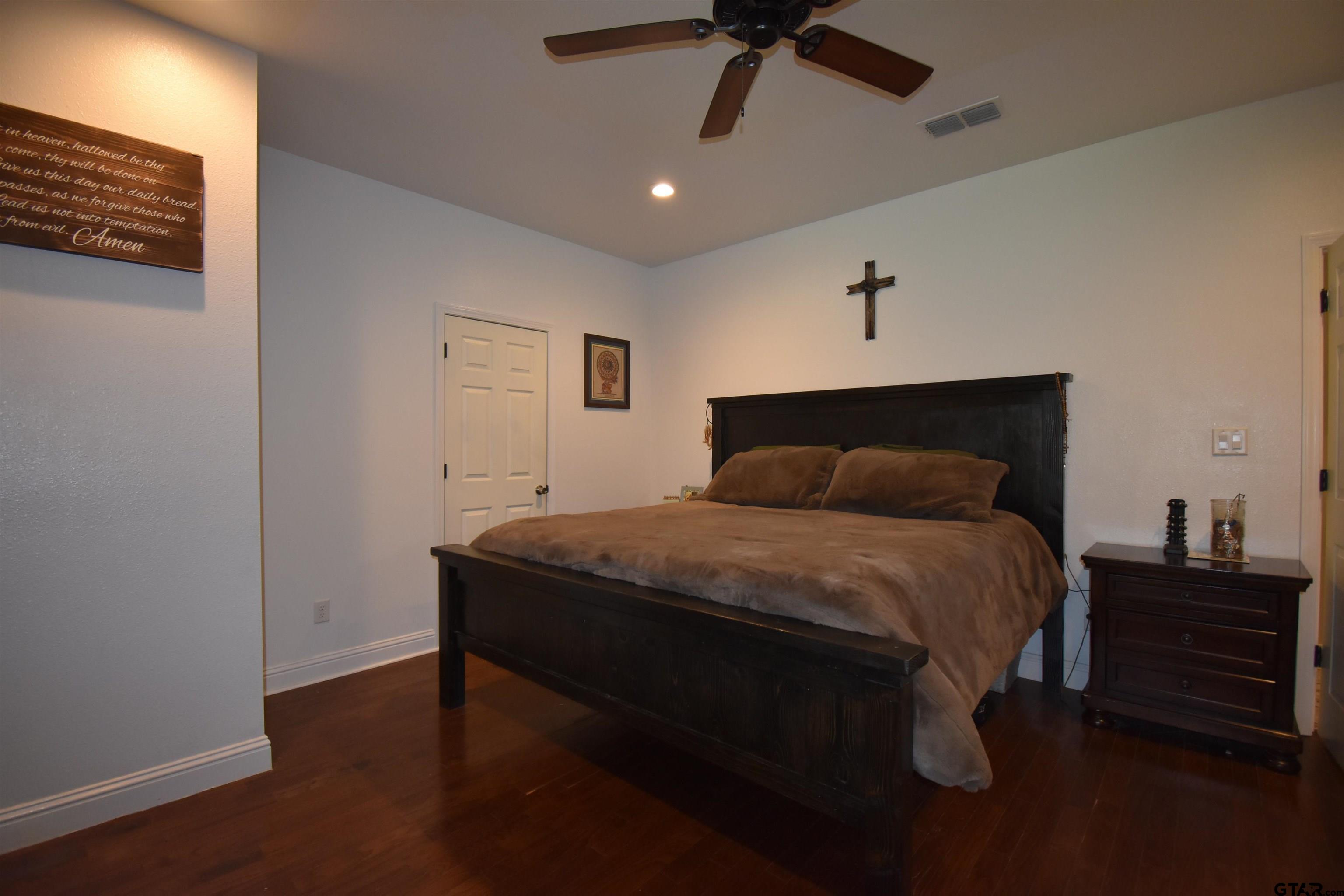 7727 Knowles Trace Tyler, TX 75708 - Photo 19 of 34 a bedroom with a bed and a night stand