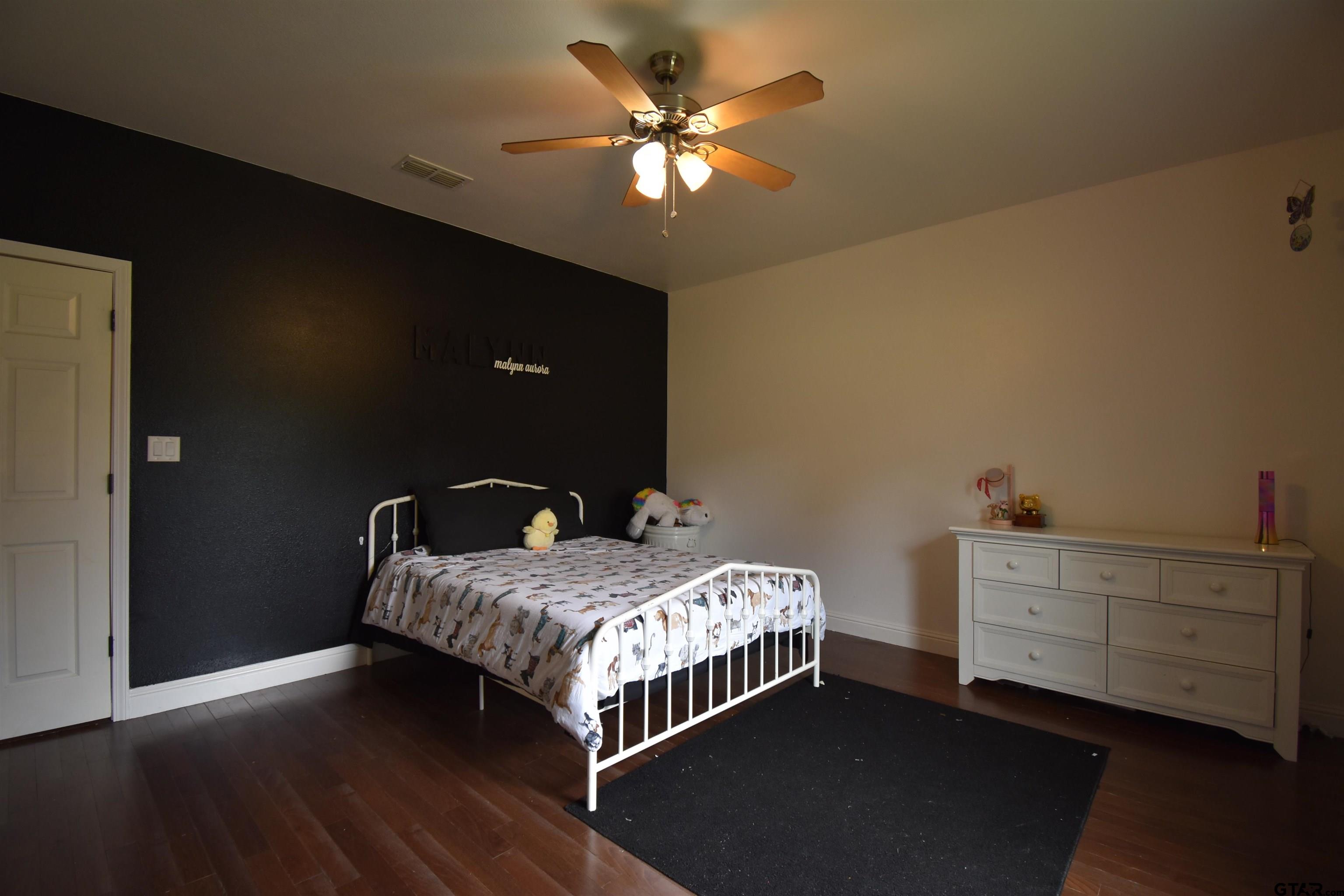 7727 Knowles Trace Tyler, TX 75708 - Photo 23 of 34 a bedroom with a bed and a chandelier