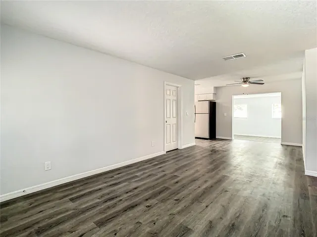 a view of empty room with wooden floor