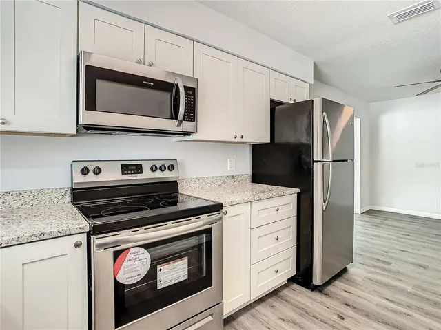 a view of empty room with wooden floor and windows