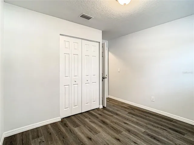an empty room with wooden floor and a window
