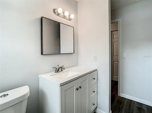 an empty room with wooden floor and ceiling fan