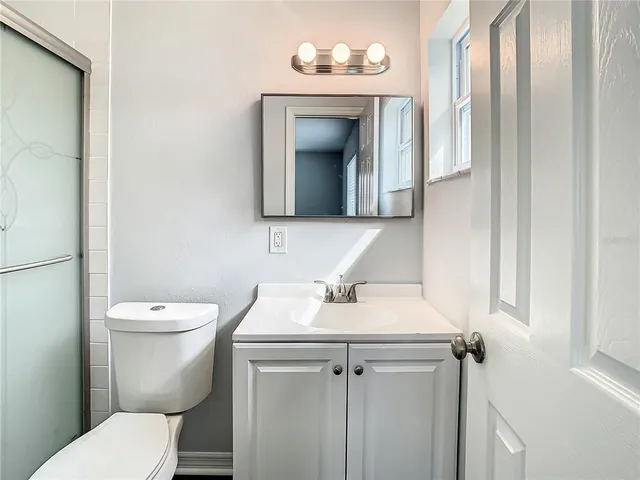 a white toilet sitting next to a shower