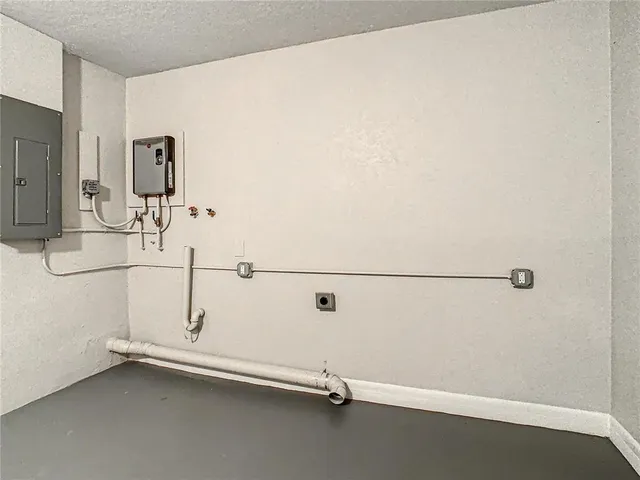 an empty room with chandelier fan and windows