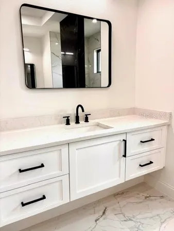 a bathroom with a sink vanity and mirror