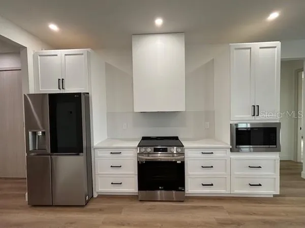 a kitchen with white cabinets and stainless steel appliances