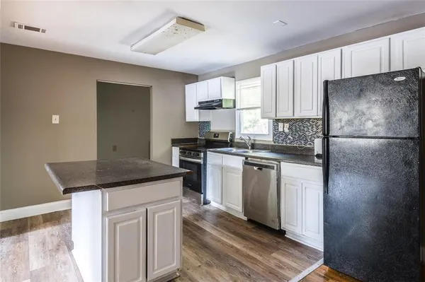 a kitchen with a refrigerator sink and cabinets