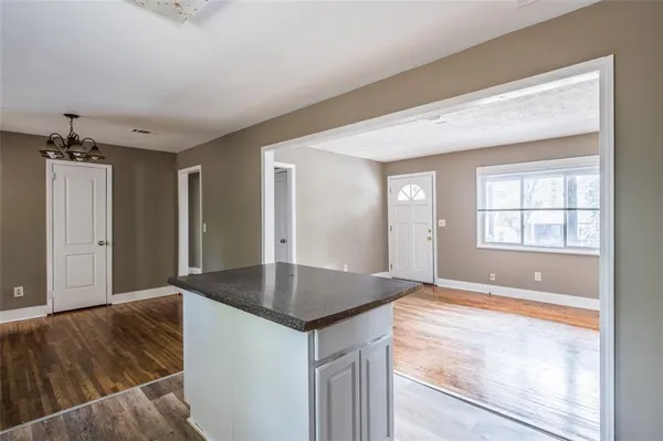a view of kitchen and hallway with wooden floor