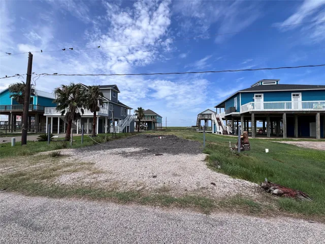 a view of a big house in front of a big yard with plants and large trees