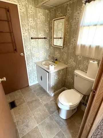 a bathroom with a granite countertop toilet a sink and a shower