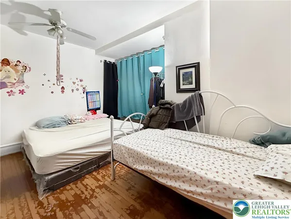 a bedroom with a bed and dresser with mirror