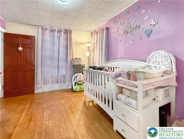 a view of a bedroom with wooden floor